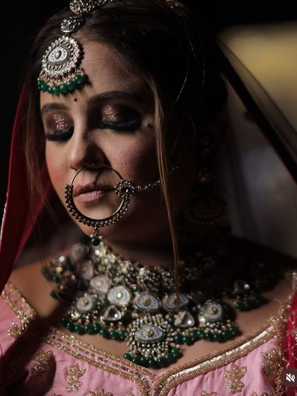 An artistic, eyes-closed portrait of the bride. This shot highlights the dramatic, dark smokey eye which provides a beautiful contrast to her pink outfit.