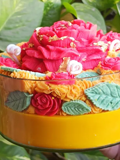 A close-up of the large rose garden jar candle, showing the gold leaf details.
