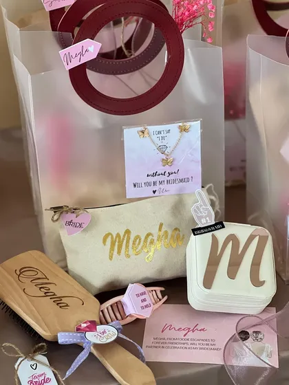 A budget-friendly yet beautiful bridesmaid hamper. It includes a personalized pouch and jewelry box, a custom hairbrush, and a lovely necklace to pop the question, "Will you be my bridesmaid?".