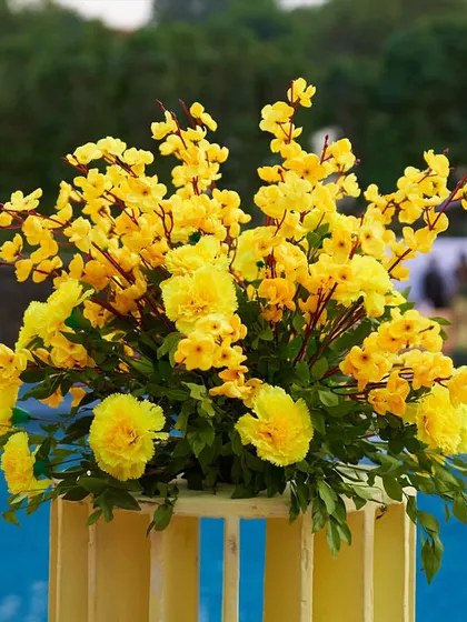 A beautiful bouquet of yellow flowers placed by the poolside, adding a pop of color and freshness to the Haldi event's ambiance.