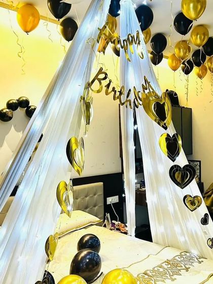 A close-up of the black and gold birthday cabana, showing the "Happy Birthday" banner and heart-shaped foil cutouts.
