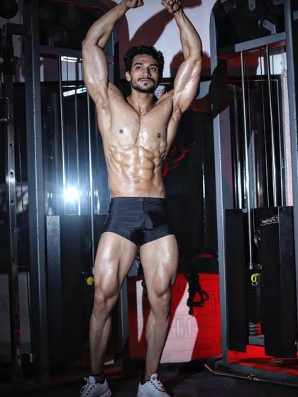 A classic vacuum pose. This highlights a tight midsection and excellent abdominal control.