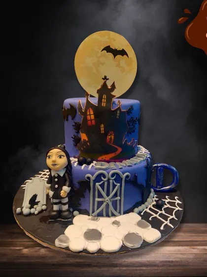 For those who love a spooky theme, I created this two-tier Wednesday Addams cake. It features a silhouette of a haunted house against a full moon, a graveyard gate, and a fondant figure of Wednesday herself.