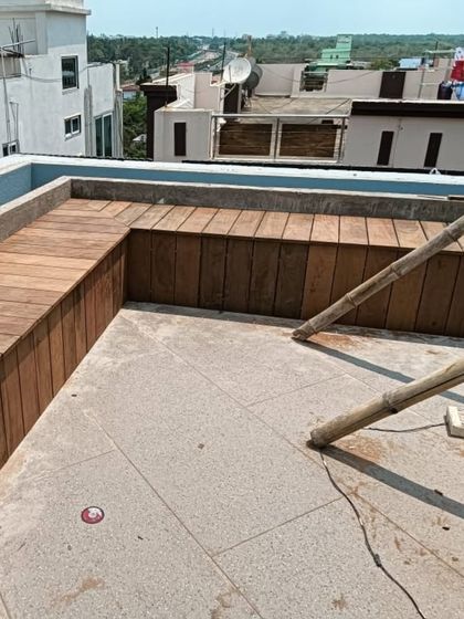 A completed custom L-shaped bench made from durable outdoor wood, providing ample built-in seating for a rooftop terrace.
