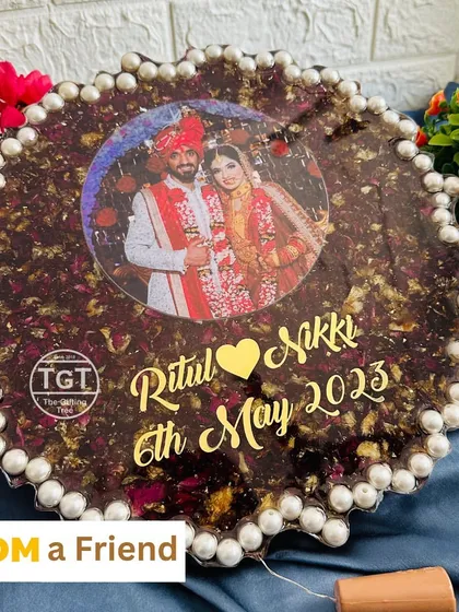A clear view of the red petal zig-zag frame, highlighting the couple's names and wedding date in gold.