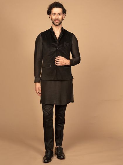 A luxurious black velvet Nehru jacket with a tonal embroidered motif on the chest. The rich texture of the velvet adds a touch of opulence, making this a perfect piece for an elegant evening affair.