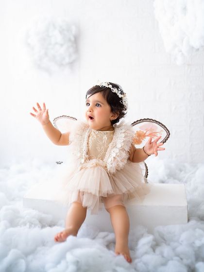 A little angel with her wings, looking up in wonder.