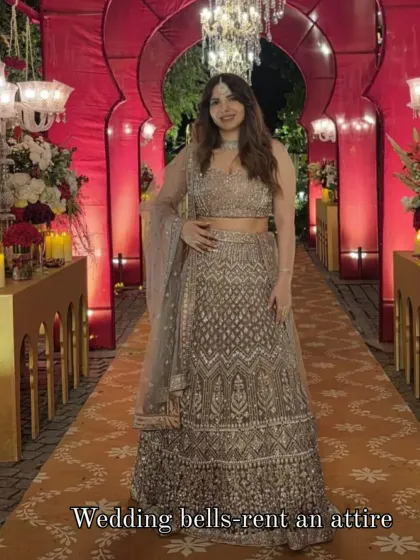 A happy client looking gorgeous in a grey embellished lehenga at an evening wedding function. Renting allows you to wear a different designer look for every event.