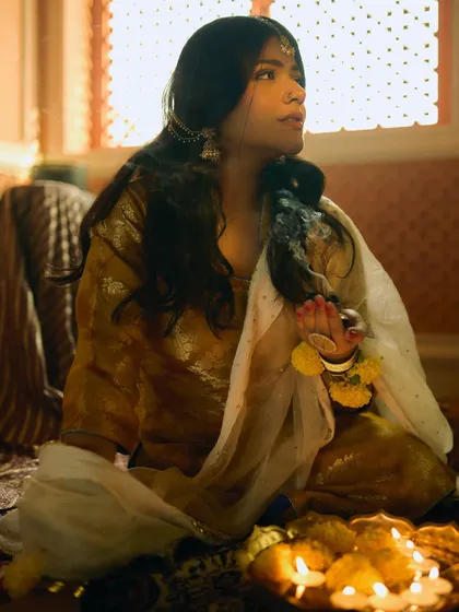 A cinematic shot from a period-themed photoshoot with Sakshi Gopal. The makeup is subtle and evocative, designed to look authentic for a historical setting.