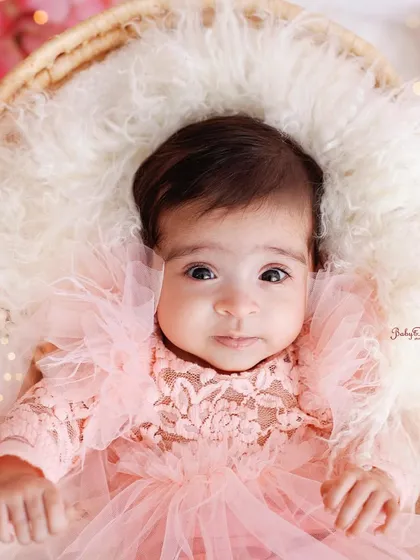 A beautiful, engaging portrait of an awake baby girl. The soft, fluffy textures and her direct gaze make this a truly captivating image.
