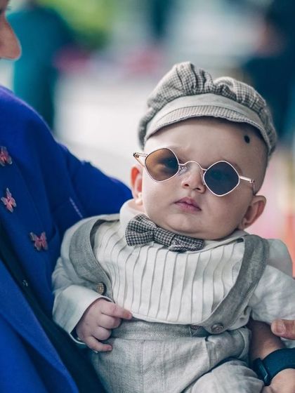The definition of a cool dude. This baby is serving serious style in his vintage-inspired suit, cap, and sunglasses.