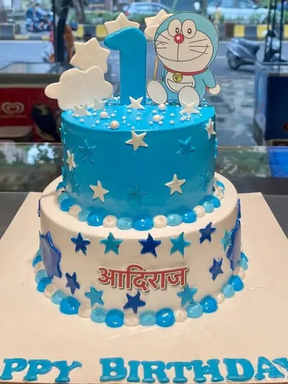 A delightful two-tier Doraemon cake perfect for a first birthday. The blue and white star-themed design and the cheerful character topper make it a wonderful choice for a little one's special day.
