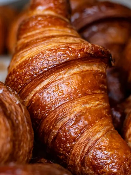 A macro shot focusing on the flaky layers of a croissant. This level of detail communicates quality and freshness to a potential customer.
