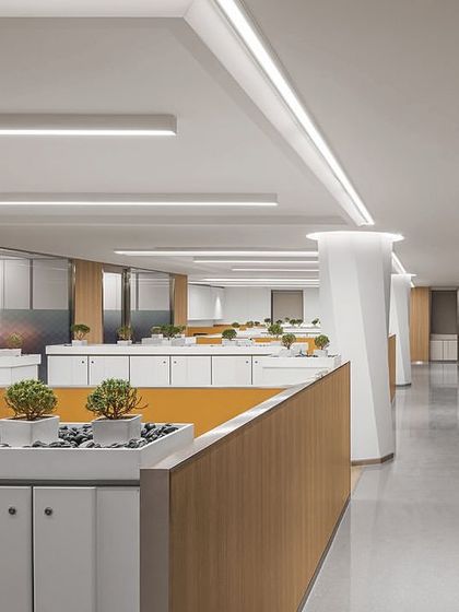 A view of the open-plan workstation area in 'The Layered Office'. We clad large structural columns in Corian with a twisted hexagonal design and integrated planters into the storage units to add visual interest and greenery.