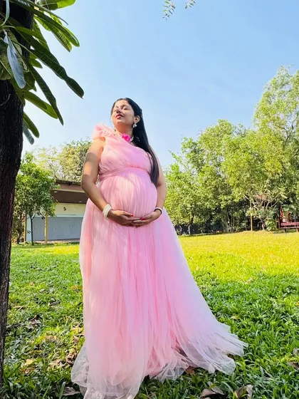 An outdoor maternity shoot gives such a fresh and natural feel. Here, the mom-to-be is enjoying a quiet moment in the park, wearing one of my flowy pink rental gowns that looks beautiful in the sunlight.