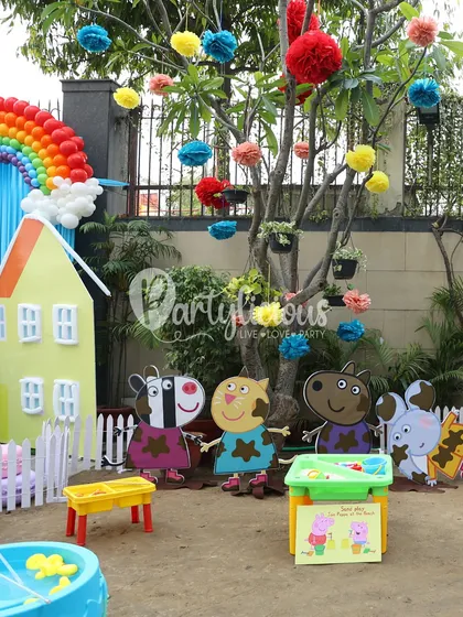 A playful scene from the Peppa Pig party, with characters in muddy puddles and a colorful house backdrop.