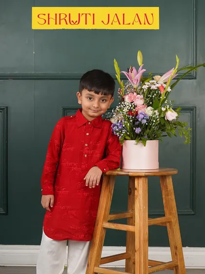 A minimal and modern red kurta set, perfect for summer weddings. The breathable fabric keeps him cool while looking stylish.