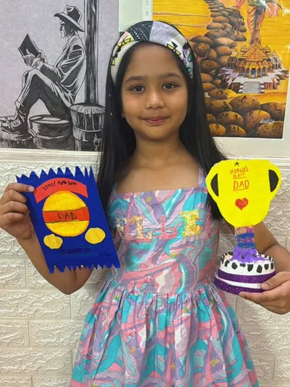 This student is ready for Father's Day with a complete gift set: a handmade card and a "World's Best Dad" trophy.
