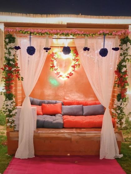 A beautifully decorated private seating area. The combination of flowers, drapes, and comfortable cushions makes it a perfect spot for a romantic evening.