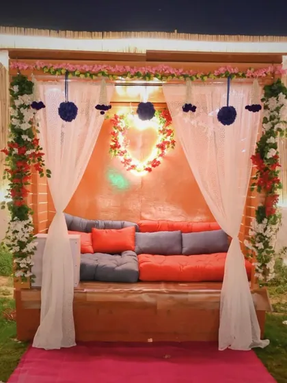 A beautifully decorated private seating area. The combination of flowers, drapes, and comfortable cushions makes it a perfect spot for a romantic evening.