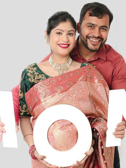 A creative and fun couple's shot using a "MOM" prop, with the baby bump perfectly framed in the 'O'.