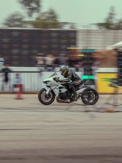 A white Kawasaki Ninja H2, one of the most powerful production motorcycles in the world, launching off the line. Its supercharged engine delivers an experience like no other.
