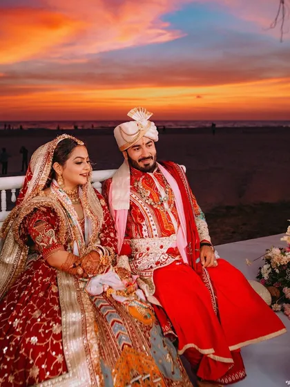 A beautiful sunset wedding in Goa, with the couple seated on the mandap against a fiery sky.