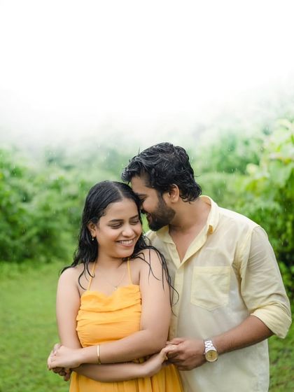 A sweet and intimate embrace amidst lush greenery. The soft, misty background adds a dreamy quality to the photo, making this a perfect shot for a romantic monsoon pre-wedding session.