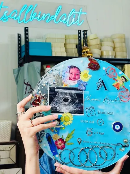 Here I am, holding up a finished baby keepsake frame in my studio. It's so fulfilling to create something that holds such immense sentimental value for a family.