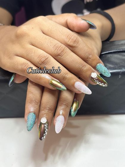An eclectic and artistic set featuring multi-chrome, turquoise glitter, and sugar glitter nails, all brought together with 3D flowers and rhinestones.