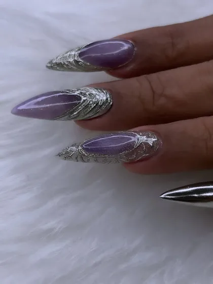 A close-up of the intricate 3D silver chrome work on these stiletto nails. The texture and shine create a liquid metal effect that is truly stunning.