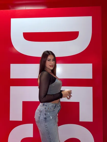 A cool, casual look for a Diesel event, featuring a grey and black top with light-wash ripped jeans.