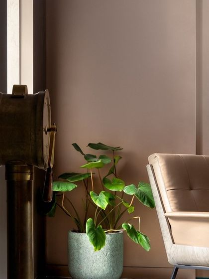 A detail shot of the reading corner in the teal bedroom. The plush armchair, warm lamplight, and curated decor create a perfect spot for quiet contemplation.
