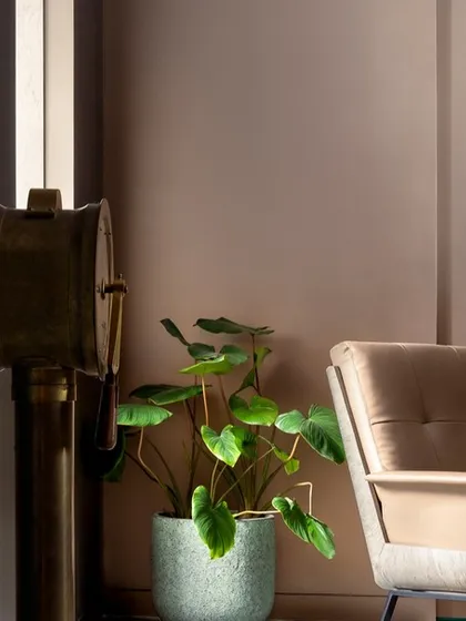 A detail shot of the reading corner in the teal bedroom. The plush armchair, warm lamplight, and curated decor create a perfect spot for quiet contemplation.