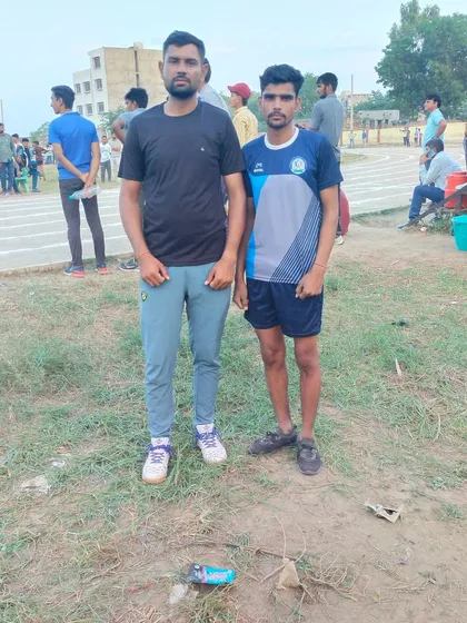 Here I am with one of our athletes who won a bronze medal in the Long Jump event. We provide specialized athletics coaching to help our students excel in track and field competitions at the district level.