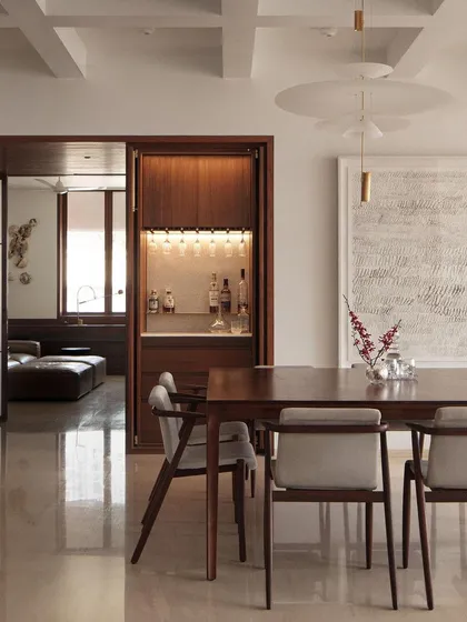 An elegant apartment on Altamount Road, Mumbai, where we focused on soft textures and refined details. The custom-built bar, crafted from rich wood, is seamlessly integrated into the dining space, demonstrating our approach to bespoke, functional furniture.