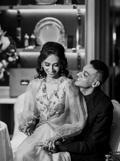 An intimate black and white photo of the couple at their reception. The groom's loving gaze and their intertwined hands tell a beautiful story.
