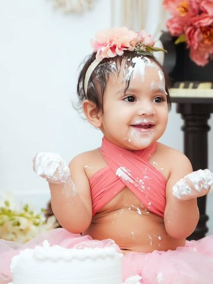 Look at that cake-covered smile. Our cake smash sessions are all about letting your baby explore and have fun while we capture their adorable reactions.