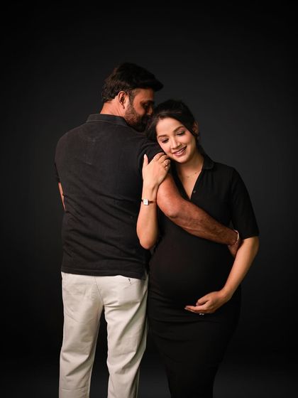An elegant and classic couple's portrait against a dark studio backdrop, emphasizing emotion and connection.