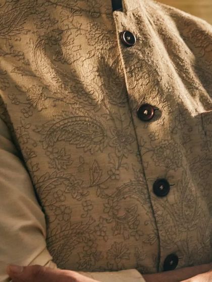 The subtle paisley and floral thread work on the Tussar silk jacket adds a layer of muted, sophisticated detail.