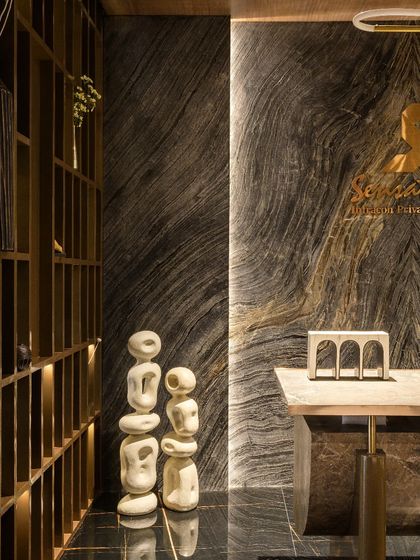 The reception desk features a stunning backdrop of book-matched marble, setting a tone of sophisticated luxury from the moment you enter. The abstract sculptures add an artistic, modern touch to the arrival experience.
