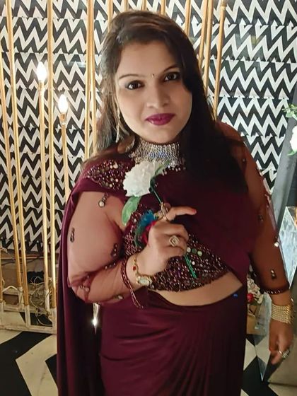 A client wearing a stylish wine-colored draped saree gown. This modern silhouette is comfortable and very chic for a cocktail event.