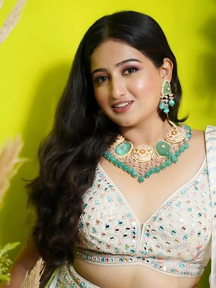 A happy and smiling shot of the model in the white floral lehenga.