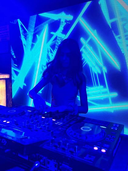 A silhouette shot against the bright blue LED screen, highlighting the atmosphere of the club.