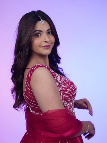 A side profile of the hot pink lehenga, showing off the maang tikka and the intricate detailing on the blouse.
