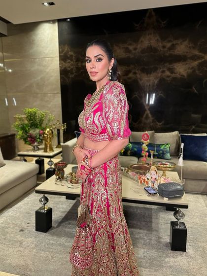 A side profile of the festive pink look, highlighting the sculpted cheekbones and the sleek ponytail that completes the modern-traditional vibe.