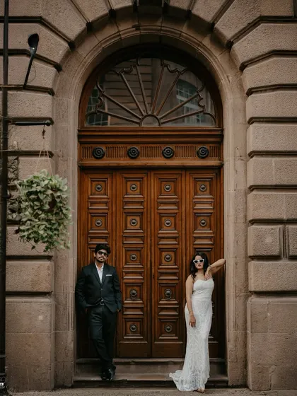 A stylish, high-fashion portrait set against a grand wooden door in South Mumbai. This showcases a more posed, editorial style for couples wanting a chic and modern pre-wedding album.