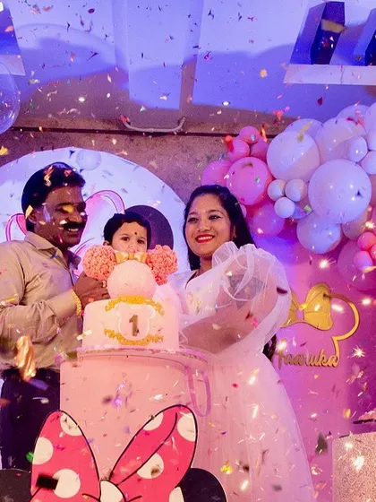 A happy family moment at Haaruka's first birthday party. The confetti shower and the beautiful Minnie Mouse-themed backdrop make for a perfect celebratory photograph.