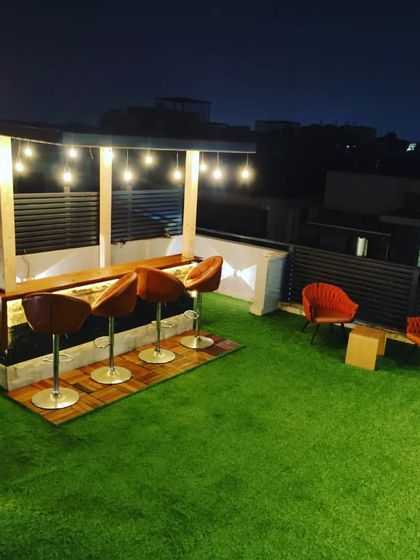A wide view of the rooftop bar area, showing how it integrates with the larger lawn space, perfect for parties and events.