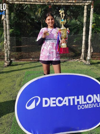 A player from our U15 girls' team posing with her winner's medal and trophy. Her smile says it all.